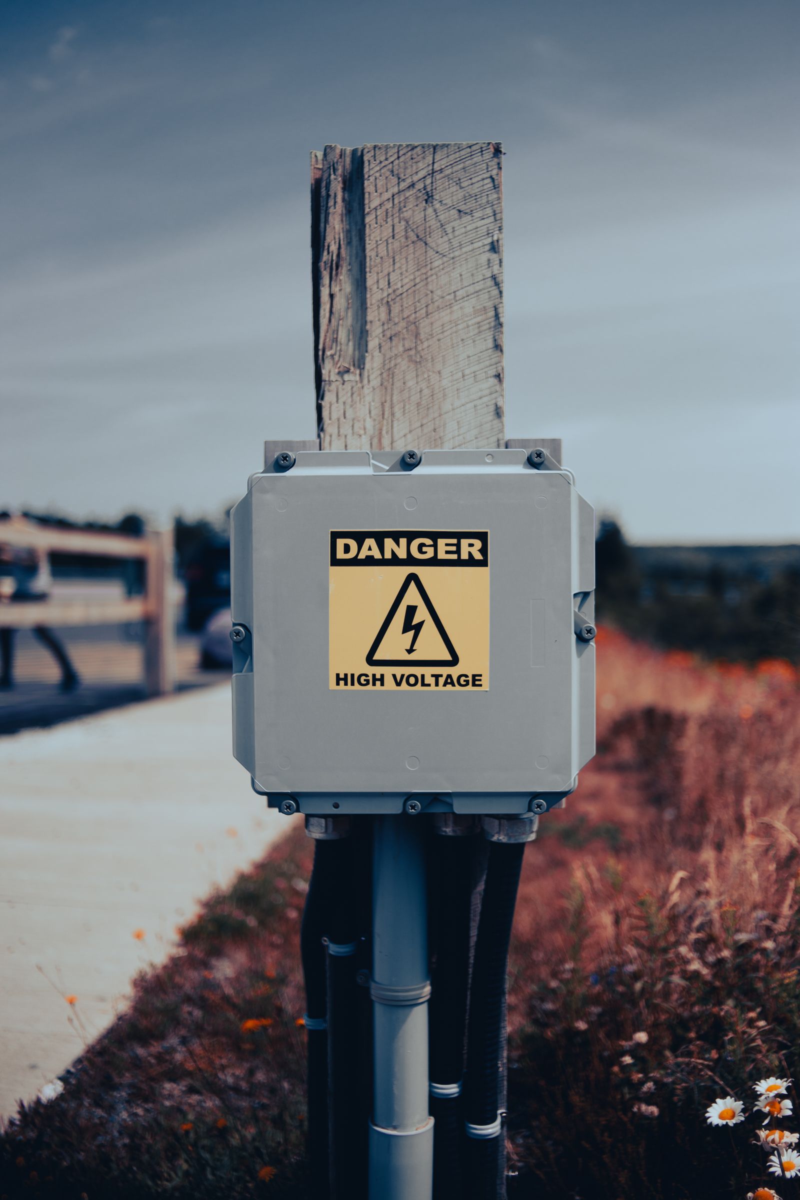 Outdoor electrical box with a high voltage warning on a pole