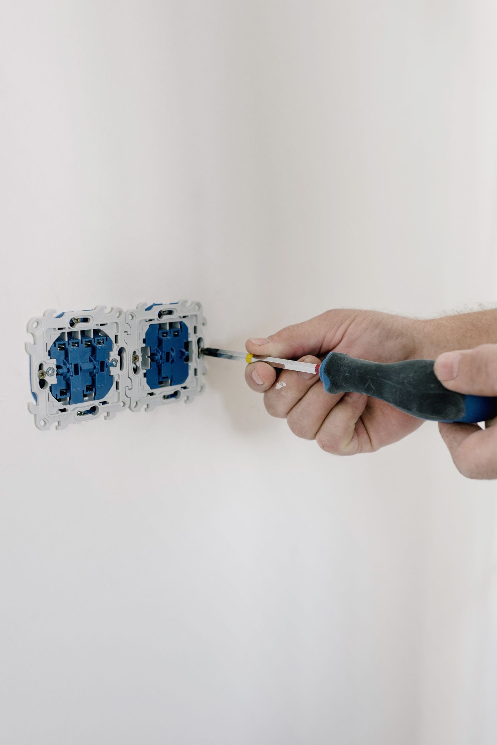 Hand using a screwdriver to install a new socket